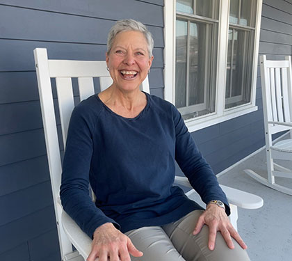 Nettie, laughing in a rocking chair on the porch of Mary's Place.