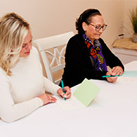 Women at a table writing