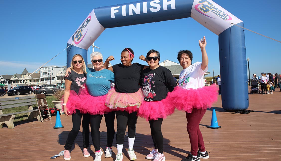 Women wearing pink tutus at finish line